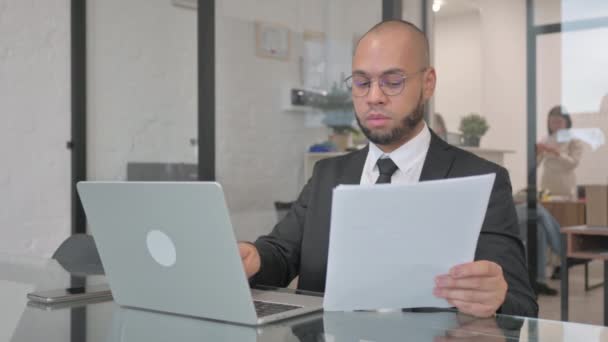 Aufgeregter Mixed Race Geschäftsmann Feiert Erfolg Bei Der Arbeit Dokumenten — Stockvideo