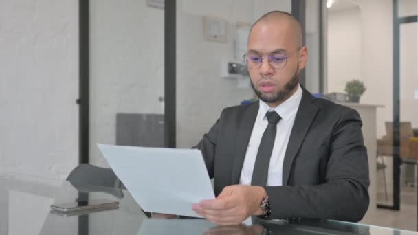 Geschäftsmann Mit Gemischter Rasse Feiert Beim Lesen Von Dokumenten — Stockvideo