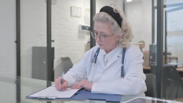 Old Lady Doctor Writing Medical Report — Stock Video