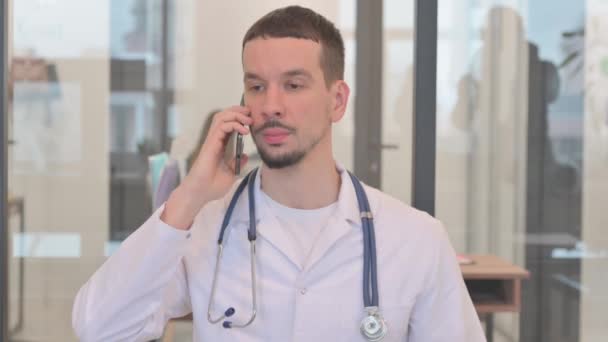 中年の医者は患者と電話で話す — ストック動画