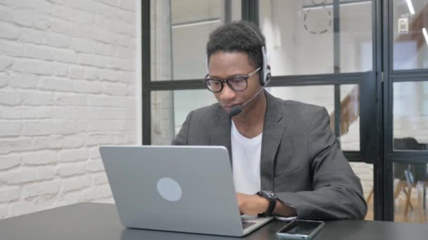 Fiatal Afrikai Férfi Headset Nézi Kamera Miközben Dolgozik Laptop — Stock videók