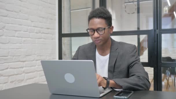 Ung Afrikansk Man Tittar Kameran När Arbetar Laptop Office — Stockvideo
