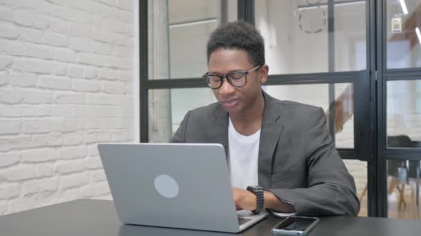 Ung Afrikansk Man Ler Mot Kameran När Arbetar Laptop Office — Stockvideo