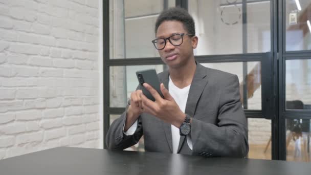オフィスの電話での成功を祝う若いアフリカ人男性 — ストック動画