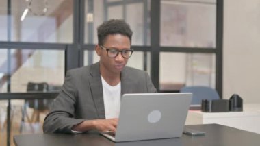 Dizüstü bilgisayar kullanan Afrikalı Amerikalı Adam Başparmağını kaldırdı