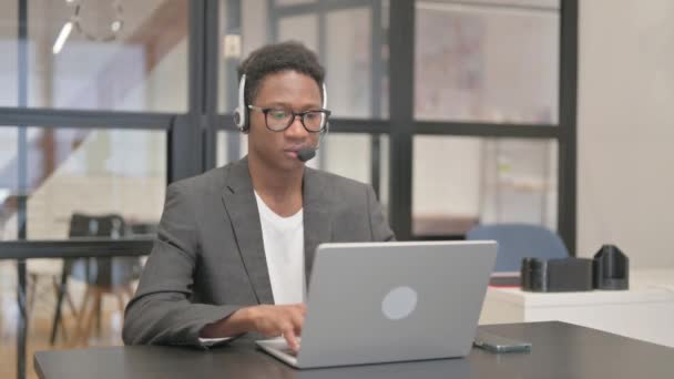 戴耳机在笔记本电脑上工作的非裔美国人 — 图库视频影像