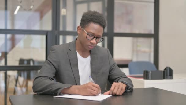 アフリカ系アメリカ人がオフィスで手紙を書く — ストック動画