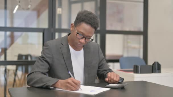 アフリカ系アメリカ人が書類の計算をする — ストック動画
