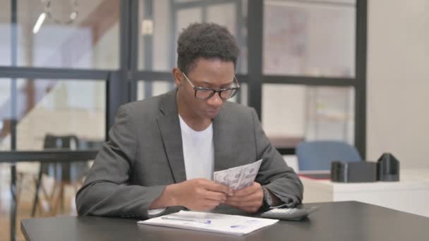 アフリカ系アメリカ人がオフィスでお金を数える — ストック動画