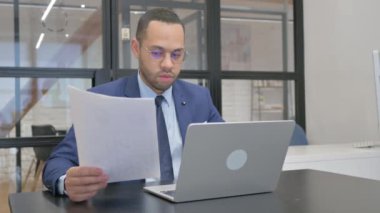 Dizüstü bilgisayar ve Belgeler Çalışırken Takım Elbiseli Adam Kutlama Yapıyor