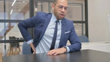 Ofiste oturan Sırt Ağrısı Olan Takım Elbiseli Adam