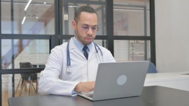 Ofisteki dizüstü bilgisayarda çalışan İspanyol doktor.
