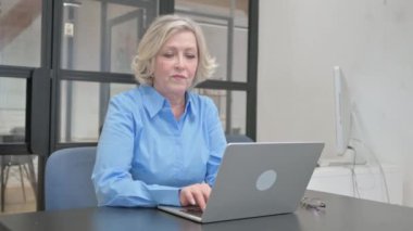 Dizüstü bilgisayarda çalışırken Yaşlı Yaşlı Kadın Kamerayı Gösteriyor