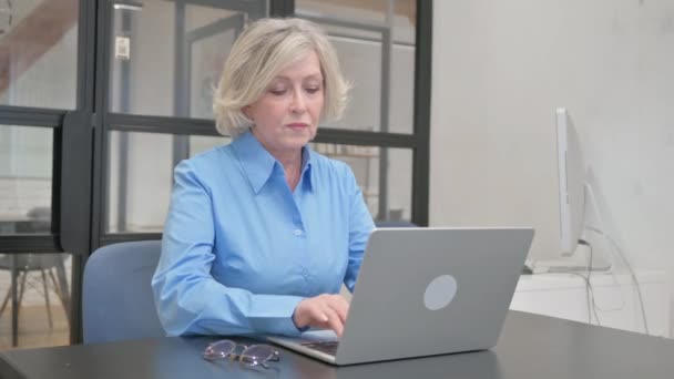 在办公室的笔记本电脑上工作的老年妇女 — 图库视频影像