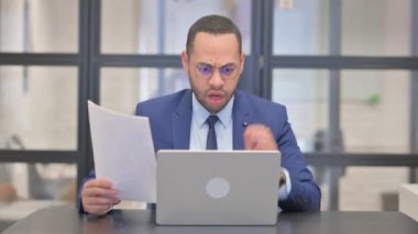 Karışık Yarış İşadamı Belgeler ve Laptop üzerinde çalışırken Kayıp 'a Tepki Veriyor