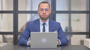 Dizüstü bilgisayar kullanan Karışık Irk İşadamından Başparmak Düşürme