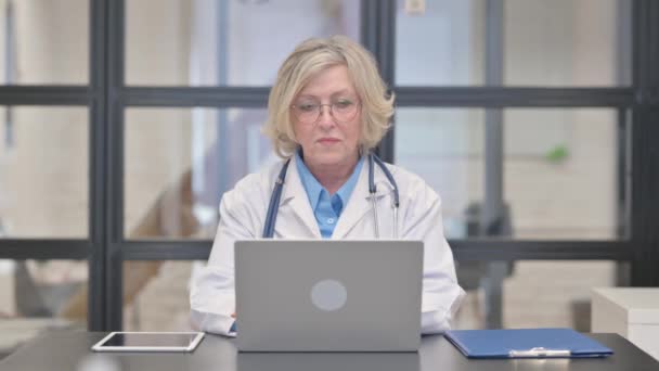 Alte Ärztin Die Während Der Arbeit Laptop Die Kamera Schaut — Stockvideo