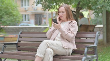 Modern Yaşlı Kadın Akıllı Telefon 'da Kayıpla Yüzleşirken Benç' te Oturuyor