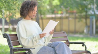Genç Afrikalı Kadın Dışarıda Otururken Belge Okuyor
