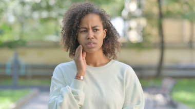 Outdoor Portrait of Young African Woman with Toothache