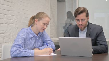 Ofiste dizüstü bilgisayarda çalışan iş adamları