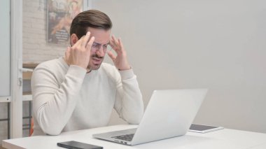 Orta yaşlı adamın işte başı ağrıyor.