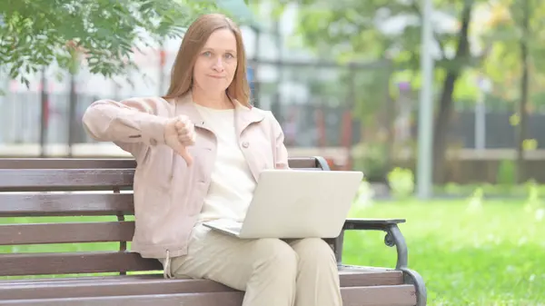 Thumbs Down by Senior Old Woman on Laptop Outdoor