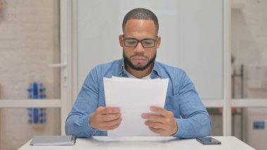 Belgeler üzerinde çalışan Karışık Irk Adamı