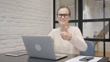 Dizüstü bilgisayar kullanan Yaratıcı Kadın Başparmağını kaldırdı