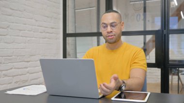 Ofiste otururken dizüstü bilgisayarda Hispanik Adam Sohbeti