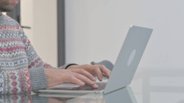 Dizüstü bilgisayarda yazan adamın yan görünümü