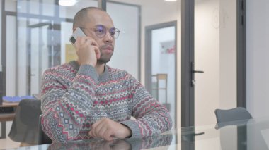 Genç İspanyol adam telefonda konuşuyor.