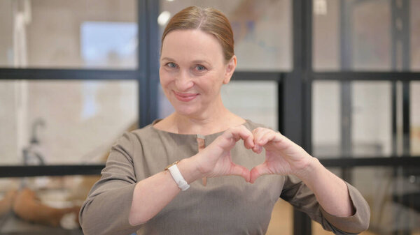 Молодая женщина с сердцем ручной работы, выражая любовь