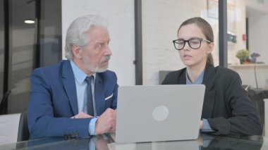 Ofiste dizüstü bilgisayarda çalışan iş adamları