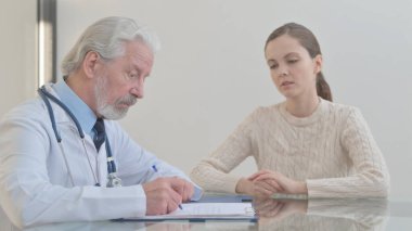 Doctor Discussing Medical Report with Patient in Clinic