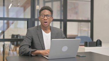 Bilgisayarda çalışırken kameraya bakan Afrikalı Amerikalı adam şok oldu.