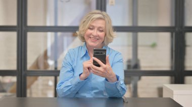 Yaşlı İş Kadını Telefonla Video Sohbeti Yapıyor