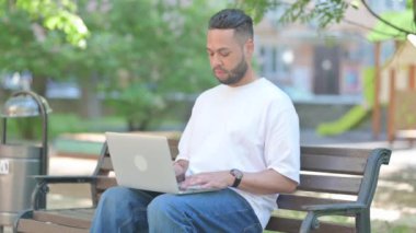 Genç adam laptop kapanış sonra Bench bırakarak