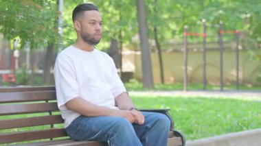 Açık havada oturan orta yaşlı adam Bench 'ten ayrılıyor.
