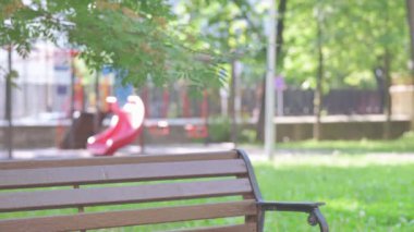 Orta yaşlı adam geliyor, bankta oturuyor ve dizüstü bilgisayar kullanıyor.