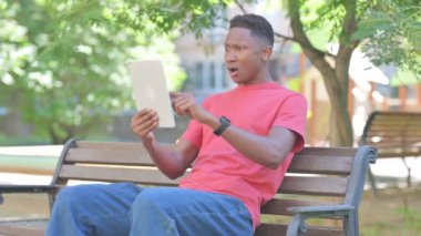 Tablette Kayıpları Olan Sıradan Afrikalı Adam Bench 'te otururken