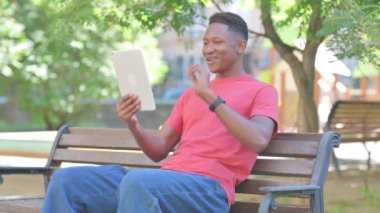 Tablet 'te Görüntü Sohbeti Yapan Sıradan Afrikalı Adam Bench' te otururken