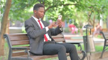 Afrikalı İşadamı Parktaki Açık havada Akıllı Telefon Kullanıyor
