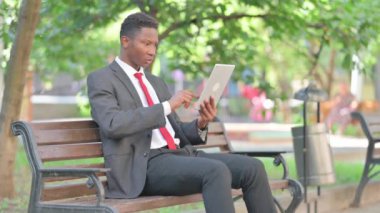 Açık havada otururken Tablet 'te Kaybı Olan Afrikalı İş Adamı