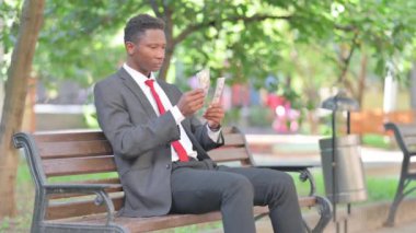 Afrikalı İş Adamı Dışarıda Otururken Para Sayıyor