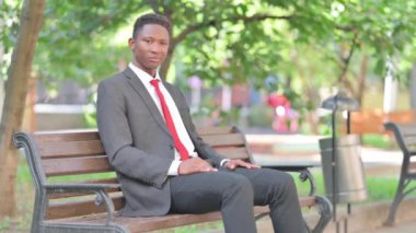 Başparmak yukarıya bankta oturan Afrika iş adamı tarafından