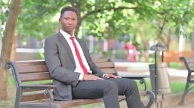 Afrikalı İşadamı Açık Hava 'da Otururken Kameraya Bakıyor