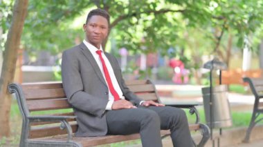 Başparmak aşağı bankta oturan Afrika iş adamı tarafından