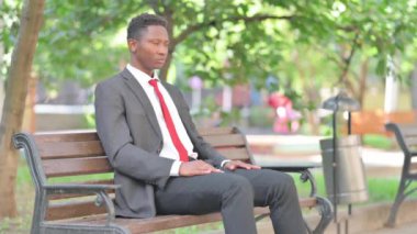 Afrikalı İşadamı Dışarıda Otururken Kamerayı Gösteriyor