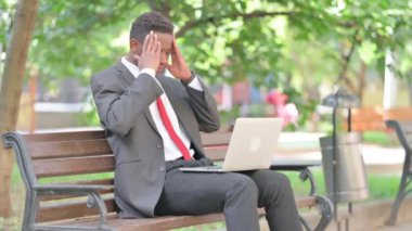 Afrikalı İşadamı 'nın kucağında laptopla migreni var.